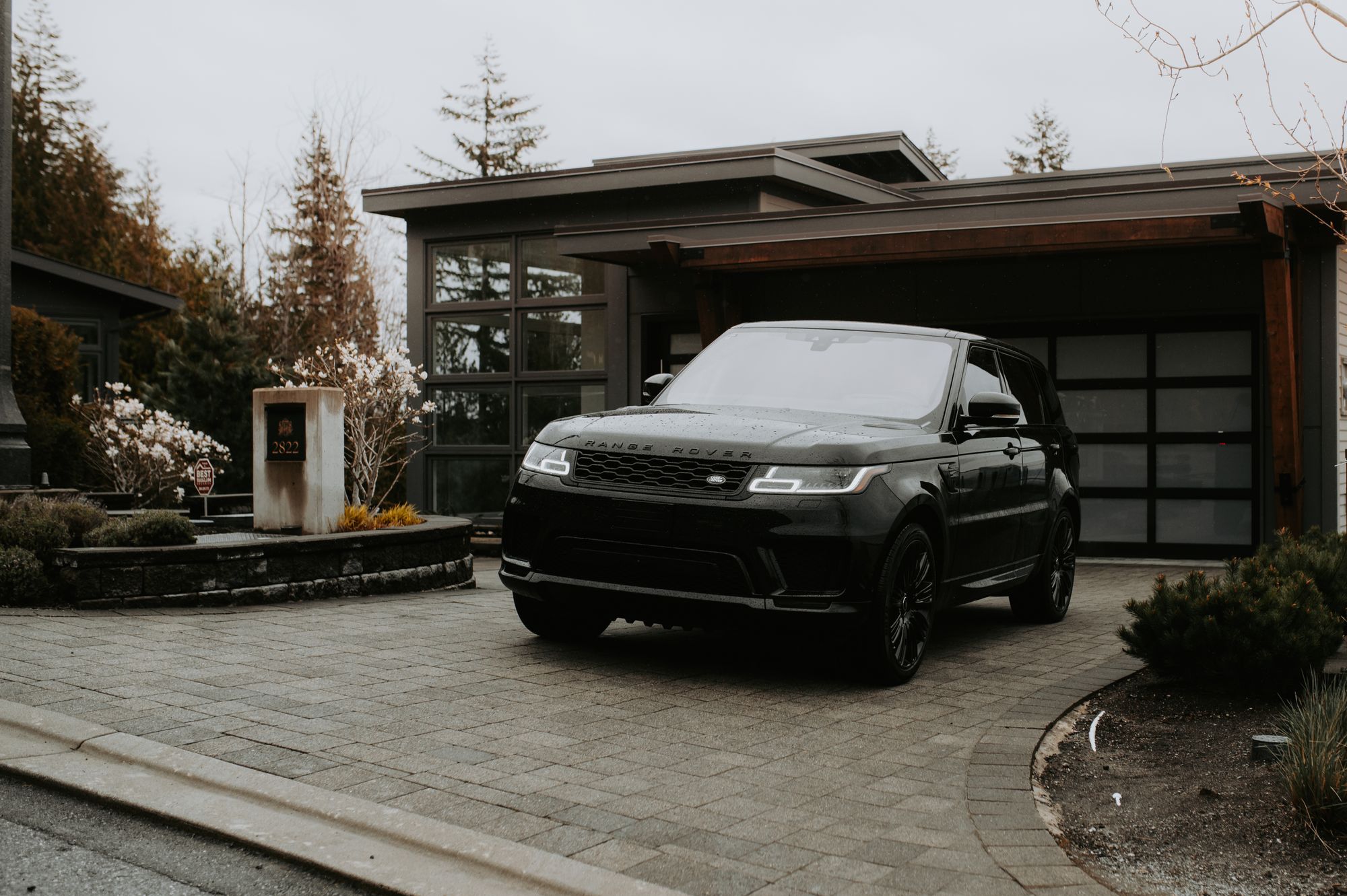 A freshly detailed glossy black SUV parked in a clean, modern residential driveway